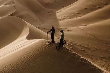 K. Bron a dos ruedas contra Broquedin en esquís sobre una duna de Perú