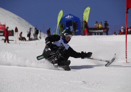 Fotografía de esquiadora en silla en un descenso 