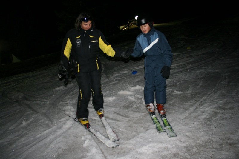 Fotografía de uno de los asistentes con un monitor esquiando de noche
