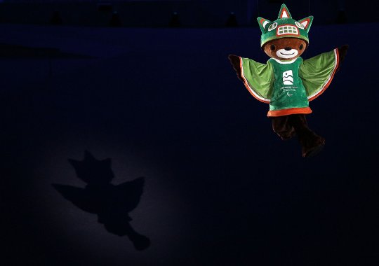 Fotografía de la ceremonia inaugural donde se ve a Sumi, la mascota de los juegos por encima del estadio simulando un vuelo