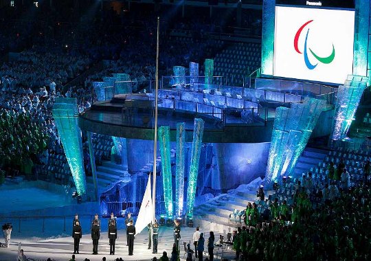 Fotografía de la ceremonia inaugural donde se ve a componentes del ejercito izando la bandera de los juegos