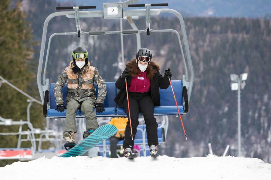 esquiadores en telesilla con mascarilla