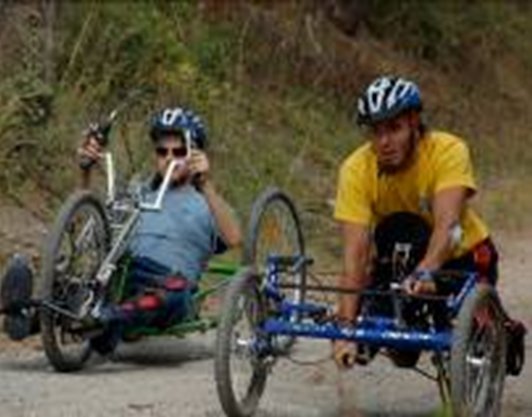 Fotografía de dos discapacitados en bicicleta adaptada