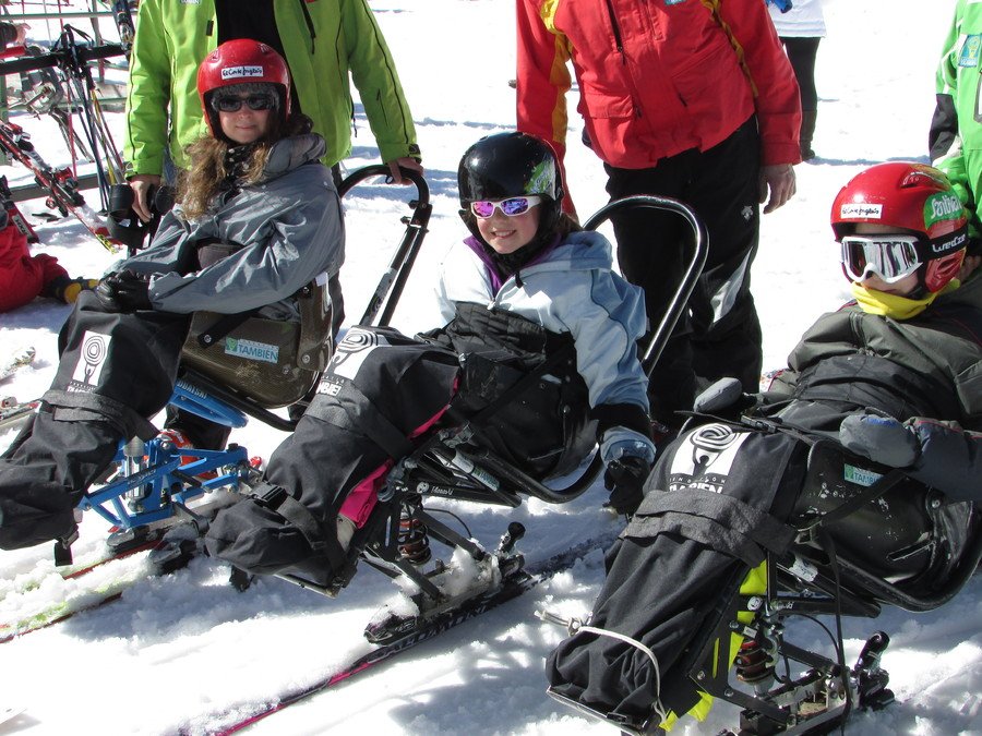 Fotografía de tres niños en silla de esquí