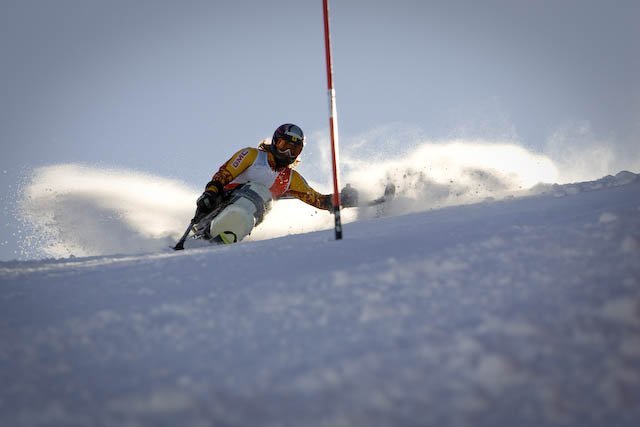 Fotografís de un esquiador en silla en un descenso