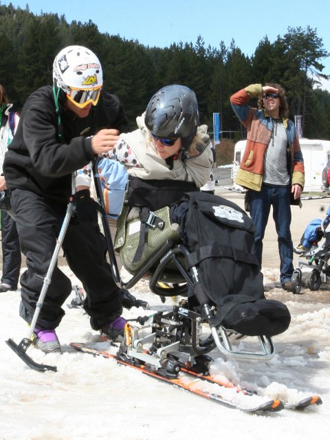 Fotografía de esquiadora discapacitada en silla con su monitor
