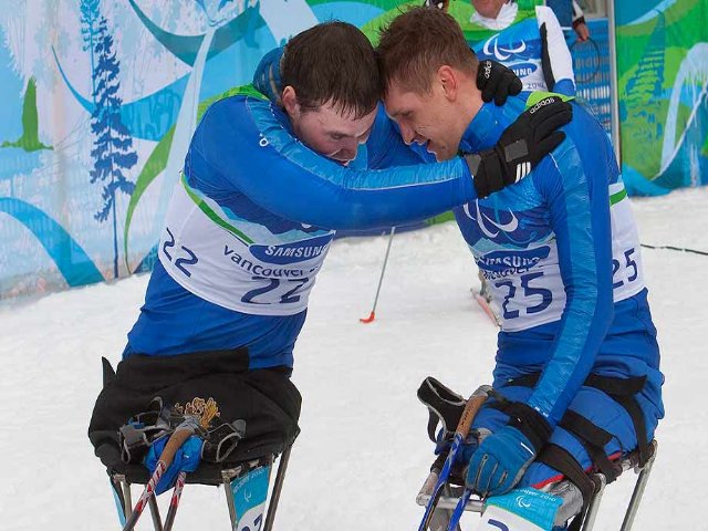 Fotografía de dos esquiadores de fondo en silla abrazados