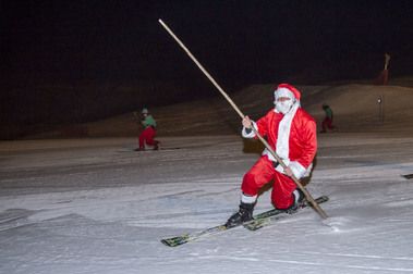 Papá Noel llega a Sierra Nevada esquiando por la pista Rio iluminada