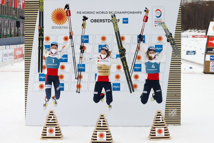 Mujeres saltando en un podio de Mundiales de esqui