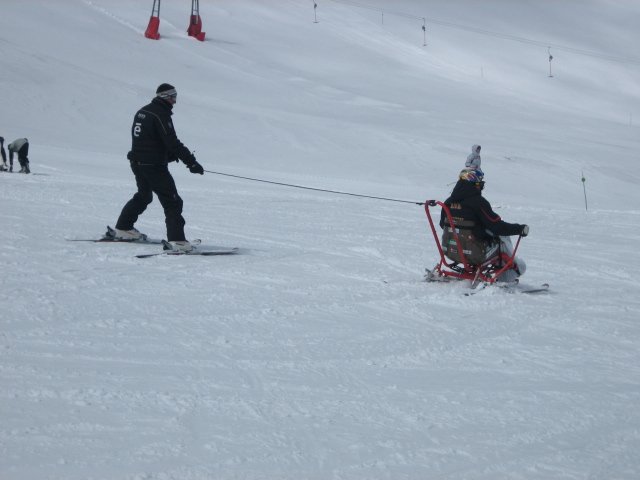 Fotografía de esquiador en Kartski con su monitor llevándole con la cuerda