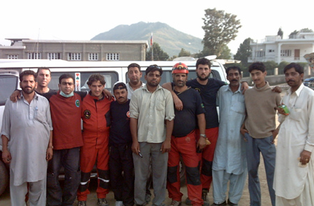 Los miembros de la Unidad Canina (con prendas de color rojo y azul), junto a miembros de los equipos pakistaníes de rescate.